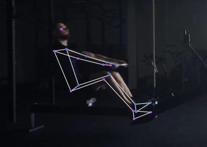 The same rower mid-drive, legs pushing and the body starting to swing back.